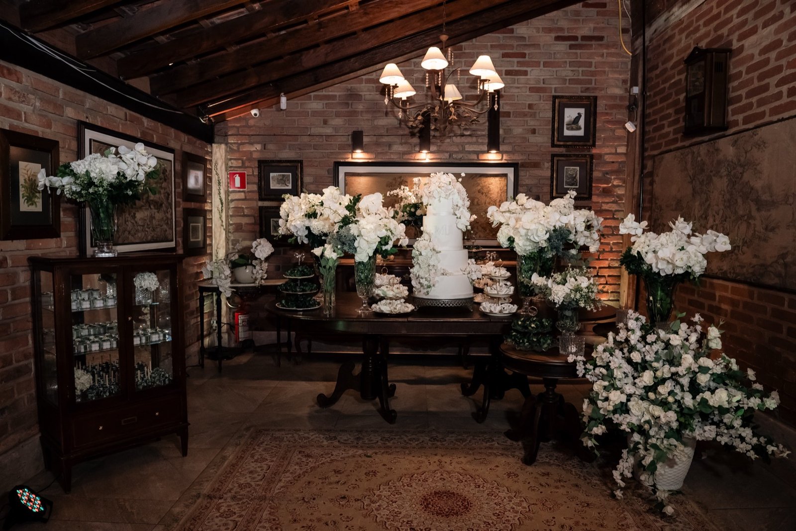 Salão amplo do Espaço Oz com lustres de cristal e mesas postas para casamento