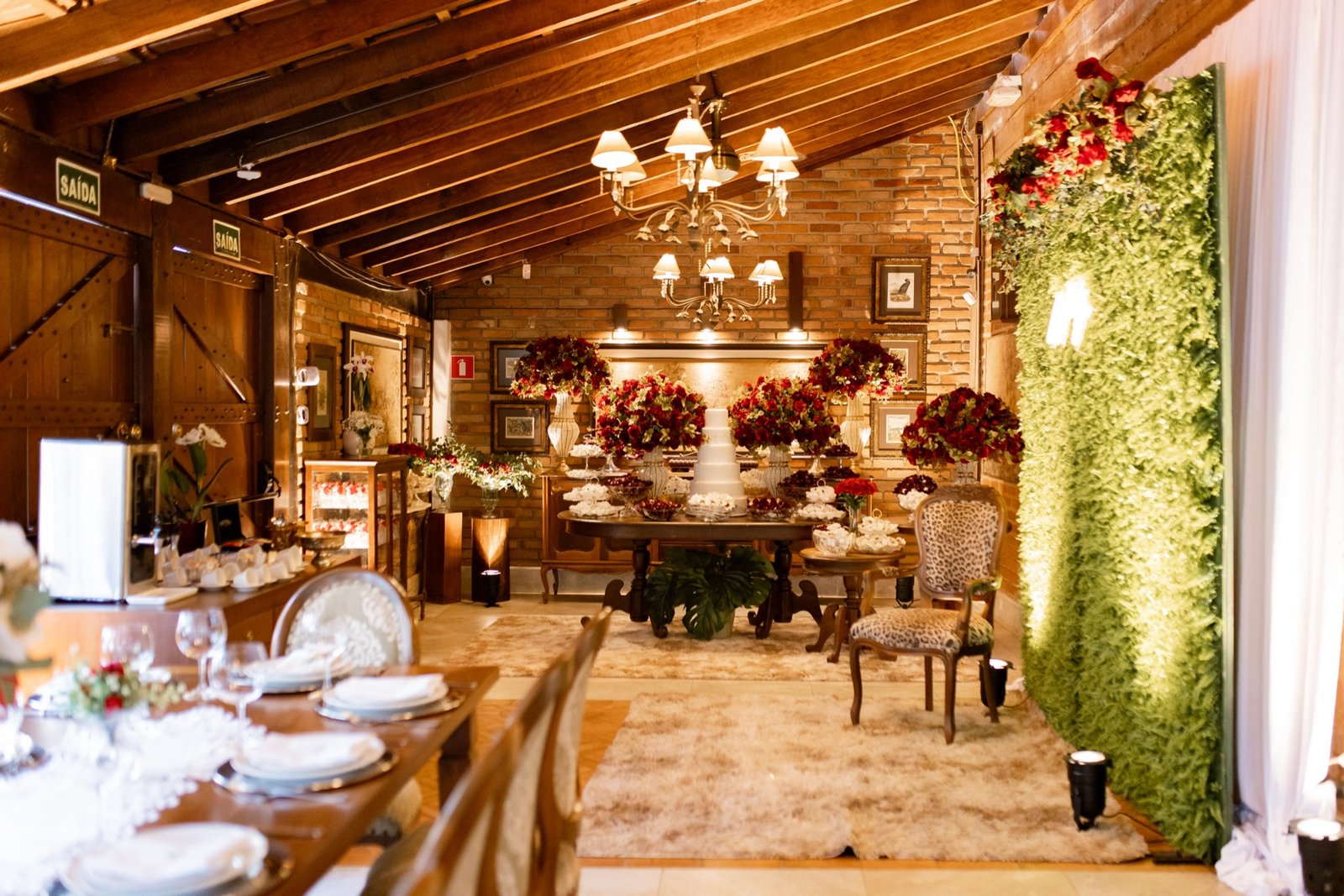 Mesa do bolo de casamento no Espaço Oz com orquídeas suspensas e doces finos